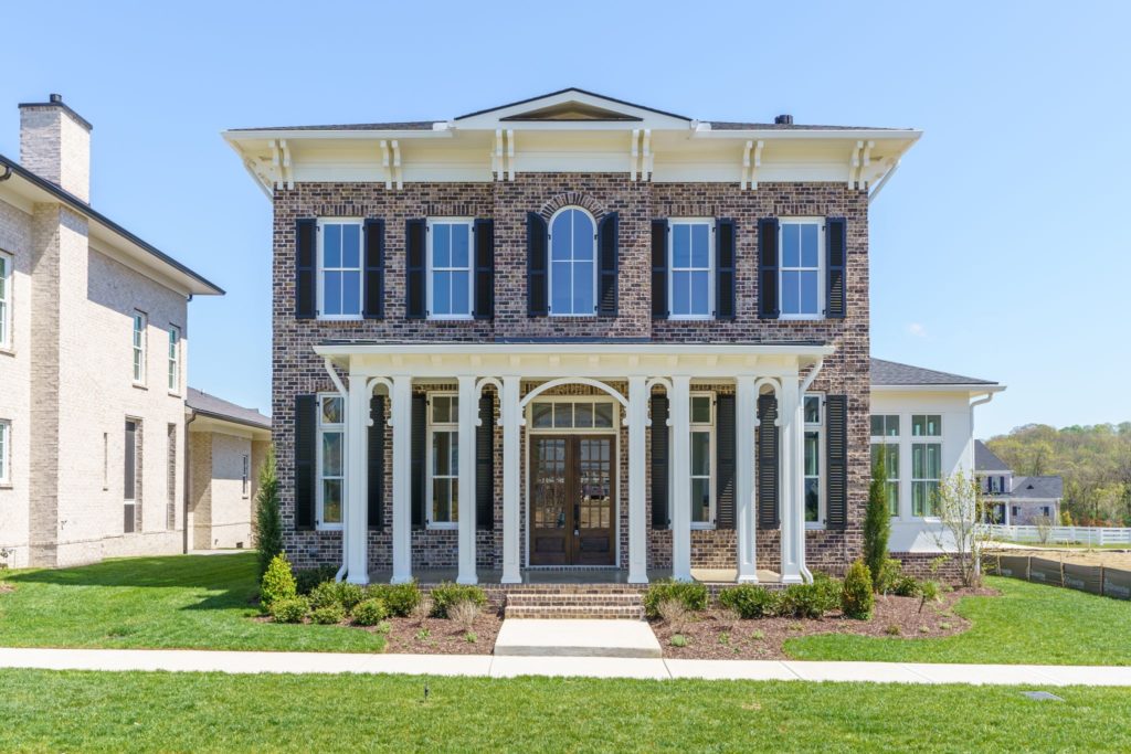A two story brick home with white pillars in stephens valley