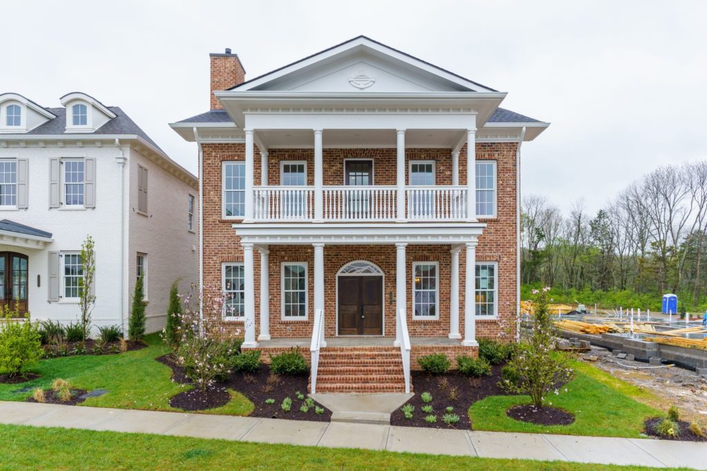 A two story brick home with an upstairs patio in stephens valley