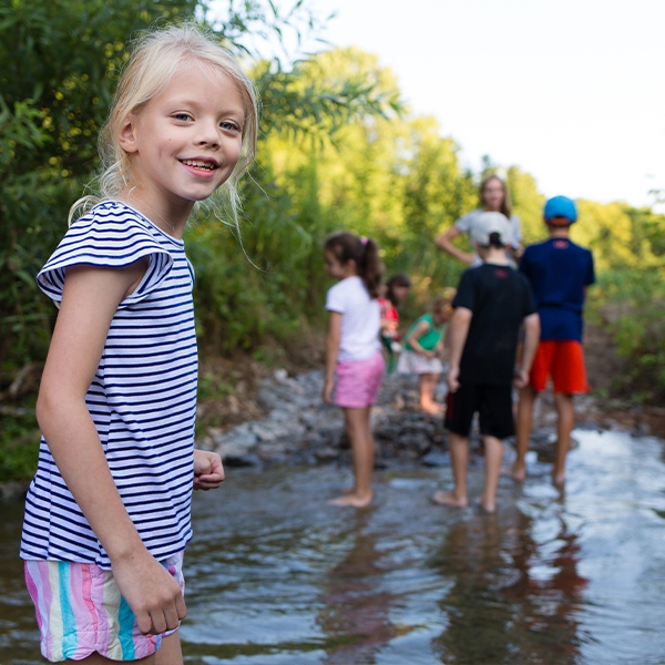A group of kids playing in a creek