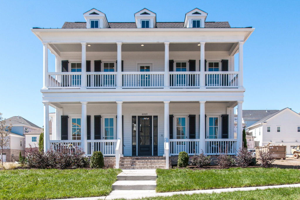 A three story white home with two patios in stephens valley